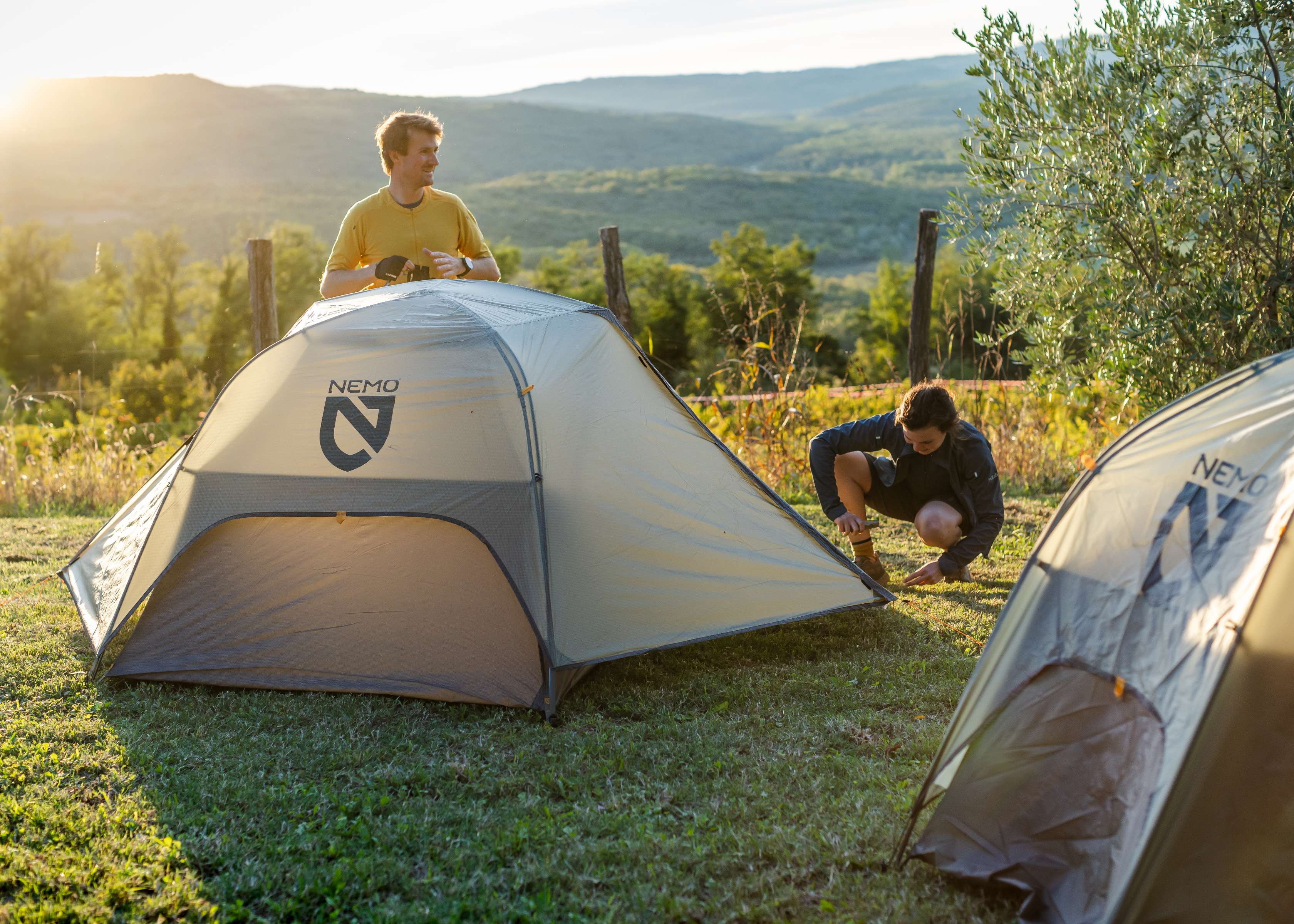 A woman and a man are pitching a tent